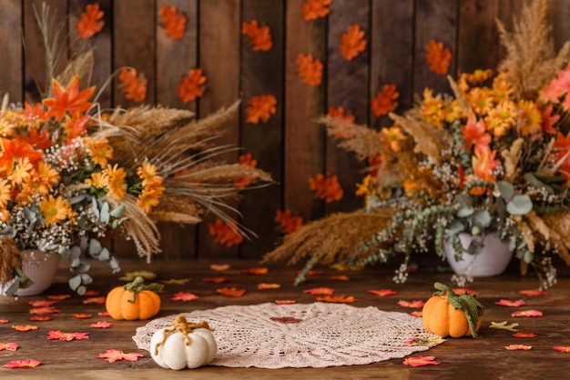 Beautiful autumn photozone with colored leaves, dry flowers and knitted pumpkins