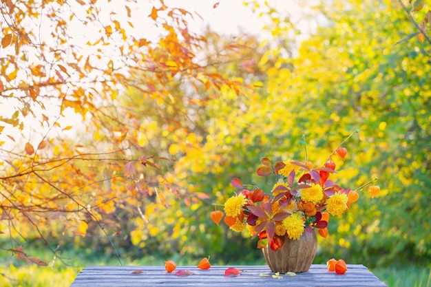 Beautiful autumnal bouquet on wooden table in garden