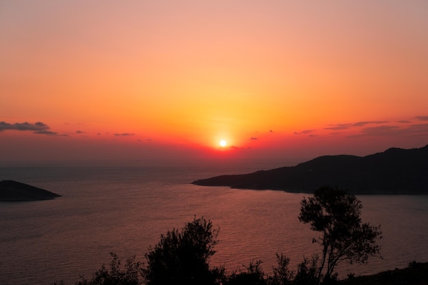 地中海の夕方の美しい畏敬の念を起こさせる息を呑むような明るいサンセットイエローまたはオレンジ色の空