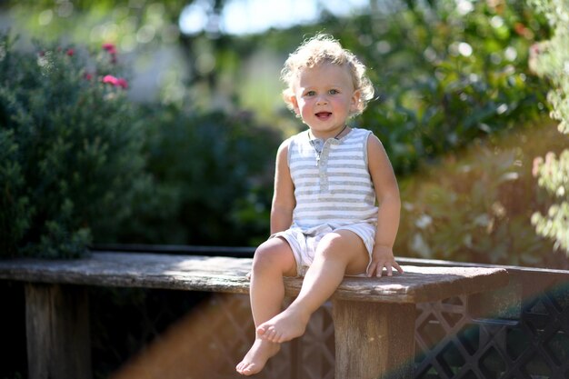 컬러 사진을 위해 사진사 포즈를 취하는 어린 얼굴을 가진 아름다운 아기