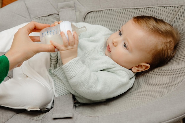 Beautiful baby drinking milk close up baby drinking milk from baby bottle with mother