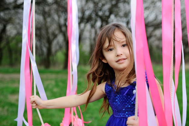 Beautiful baby girl ride on a swing