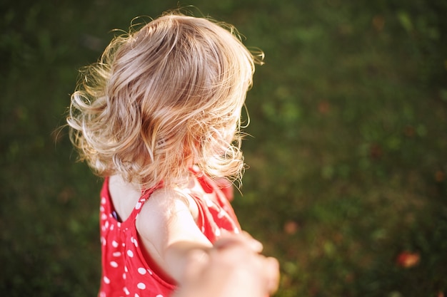 Beautiful baby hair the child holds the hand of the parent and plays