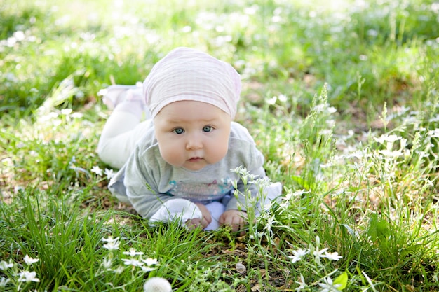 写真 夏の公園の芝生に横たわっているスカーフの美しい赤ちゃん