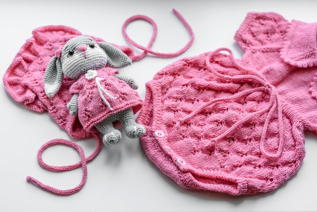 Bellissimi vestiti lavorati a maglia per bambini e un giocattolo per un neonato