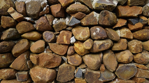 Beautiful background pattern image of a wall made of round stone red color rocks Texture