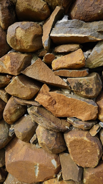 Beautiful background pattern image of a wall made of round stone red color rocks Texture