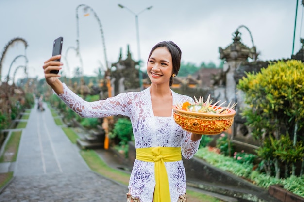 Beautiful balinese woman wearing kebaya taking self portrait