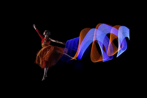 Beautiful ballerina dancer with colorful lights effect 