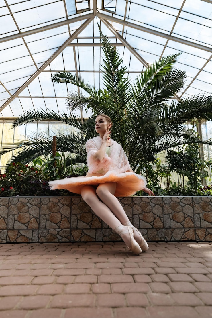 Photo beautiful ballerina in pointe shoes in a greenhouse among palm trees