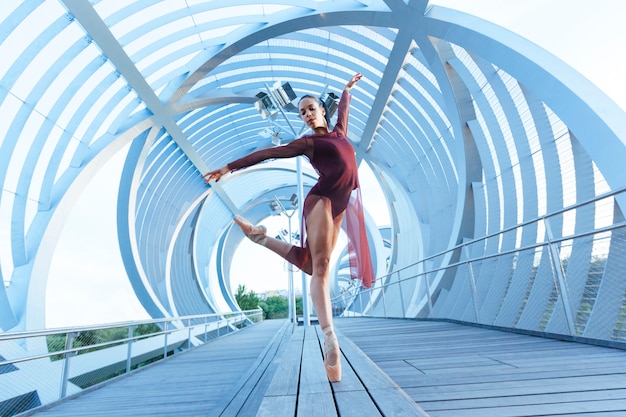 Beautiful ballet pose of a woman dancer with an incredible perspective