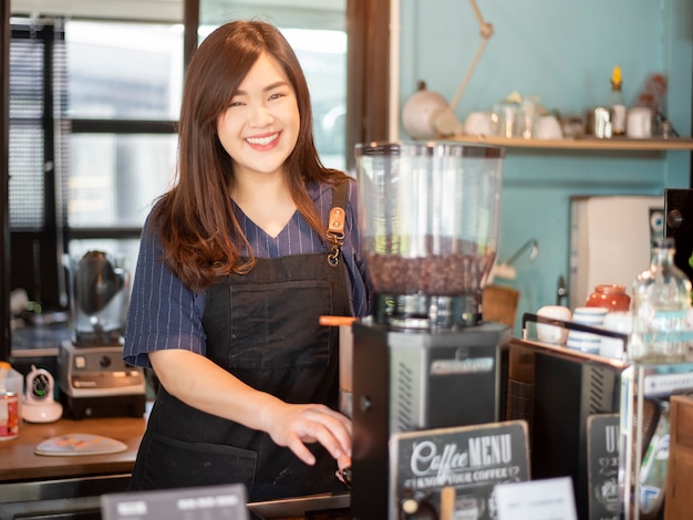 아름 다운 바리 스타는 그녀의 커피 숍에서 웃