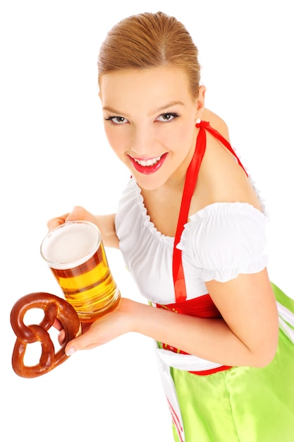 a beautiful bavarian waitress holding a beer and a pretzel over white background