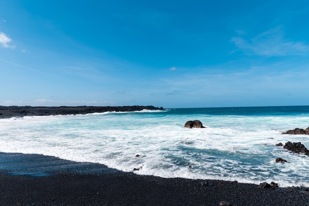 Lanzarote 섬에 아름다운 해변. 화산 산 / 대서양과 멋진 해변으로 둘러싸인 모래 해변. Lanzarote. 카나리아 제도