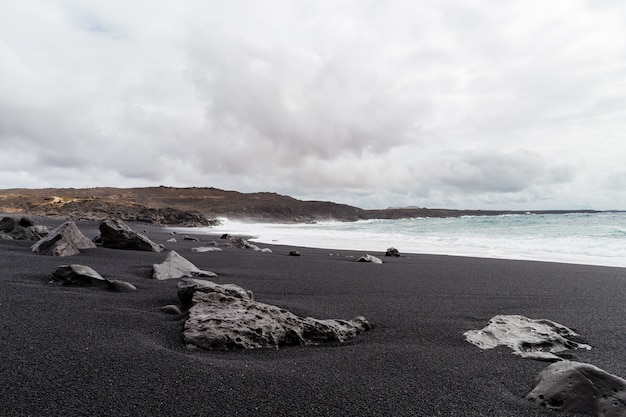 Beautiful beach on the island of Lanzarote. Sandy beach surrounded by volcanic mountains / Atlantic Ocean and wonderful beach. Lanzarote. Canary Islands