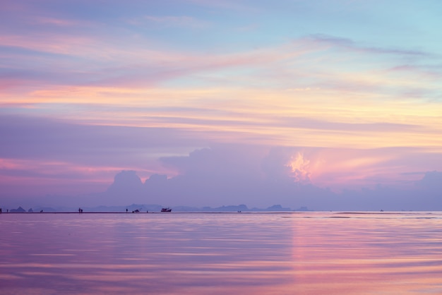 Beautiful beach sunset with big rain clouds and golden light sky 