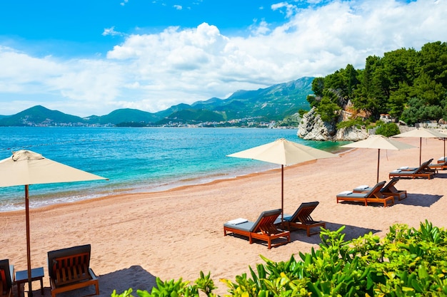 Beautiful beach with chaise lounges in Sveti Stefan near Budva, Montenegro. Luxury resort at Adriatic sea.