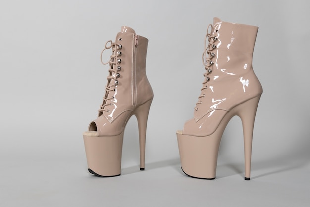 Beautiful beige shiny shoes for pole dance or striptease on a gray background