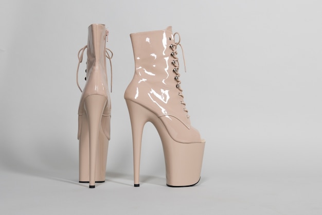 Beautiful beige shiny shoes for pole dance or striptease on a gray background