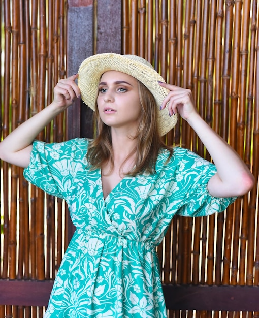 Foto bella donna bielorussa in abito verde con cappello