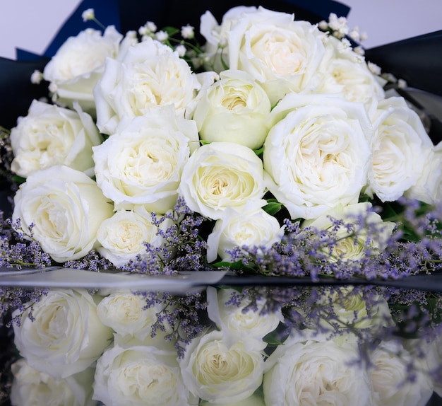 Bellissimo grande e lussuoso bouquet di rose bianche disposte in un mazzo con riflesso sul pavimento