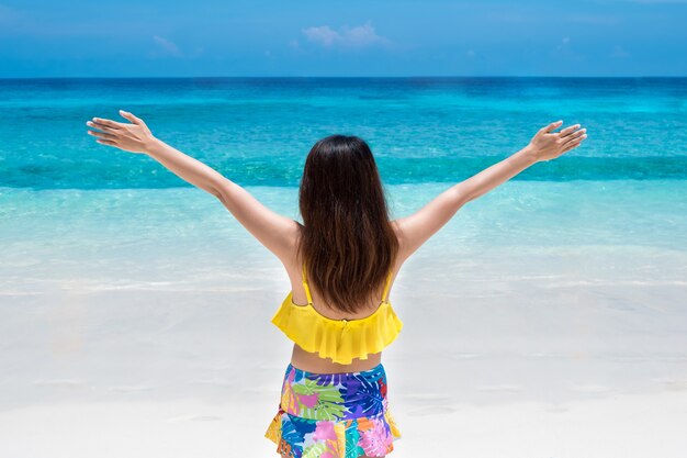 Beautiful bikini woman stand and enjoying tropical beach nature 