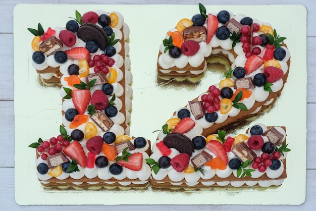 Beautiful birthday cake in the shape of the number twelve on a Golden substrate top view