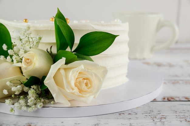 Beautiful birthday cake with white roses on white background.