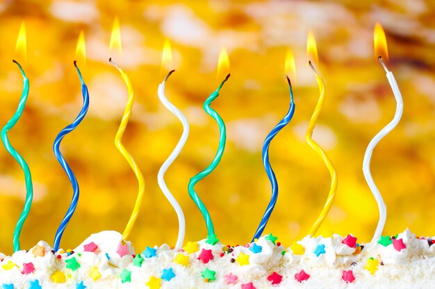 Beautiful birthday candles on yellow background