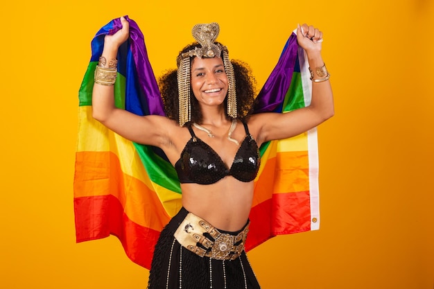 Beautiful black brazilian woman in cleopatra carnival clothes holding lgbt flag