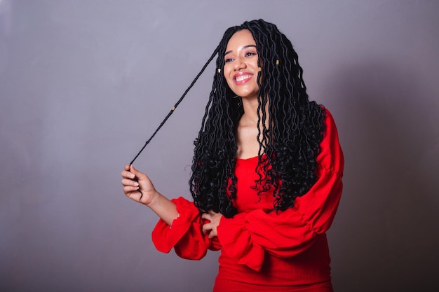 Beautiful black Brazilian woman dressed in red messing with the hair