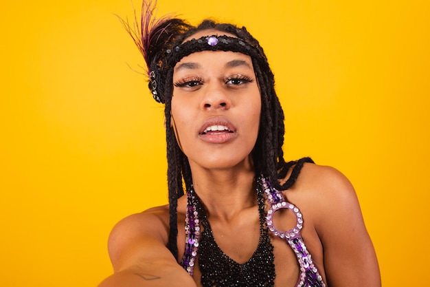 Фото Красивая черная бразильянка в фиолетовой карнавальной одежде делает автопортрет