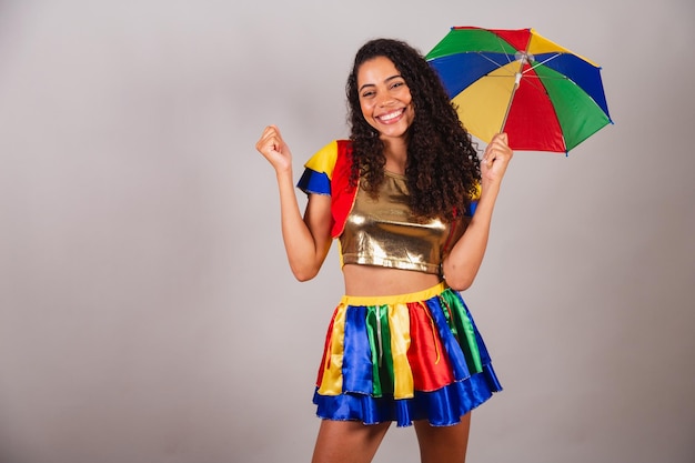 Beautiful black brazilian woman with frevo outfit and umbrella\
carnival dancing frevo typical brazilian carnival dance
