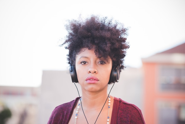 beautiful black curly hair african woman listening to music