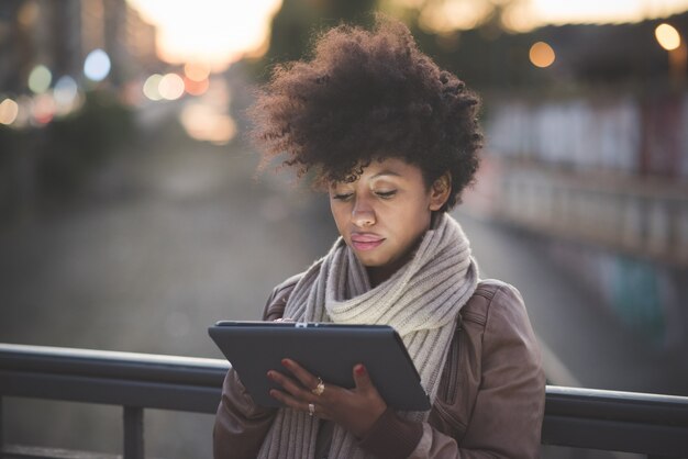 Photo beautiful black curly hair african woman using tablet