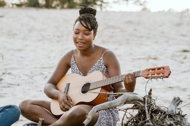 Beautiful black girl playing guitar great sings talented young student in a dress