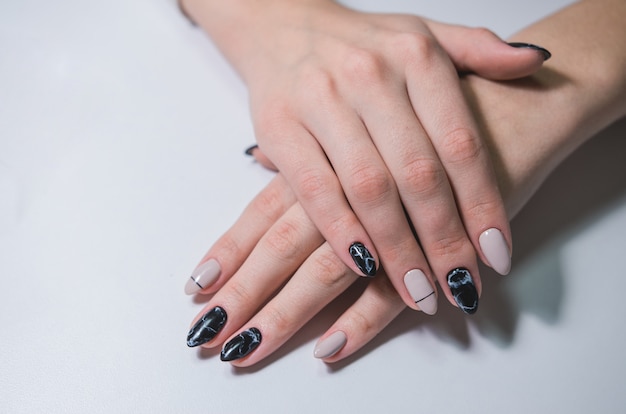 Beautiful black and white manicure on female hand. Close-up nail art 