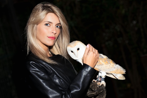 Beautiful blond girl caresses a Barn owls