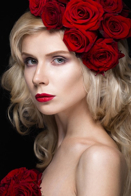 Beautiful blond girl in dress and hat with roses, classic makeup, curls, red lips. Beauty face.