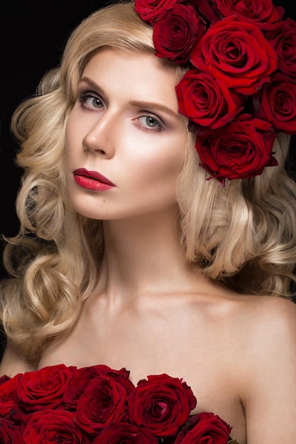Красивая блондинка в платье и шляпе с розами, классический макияж, кудри, красные губы. Красота лица.