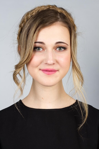 Beautiful blond girl with blue-green eyes on a white background