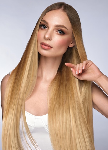 Bella ragazza bionda con capelli perfettamente lisci e viso e capelli di bellezza trucco classico