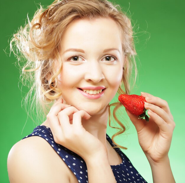 Beautiful blond holding a strawberry