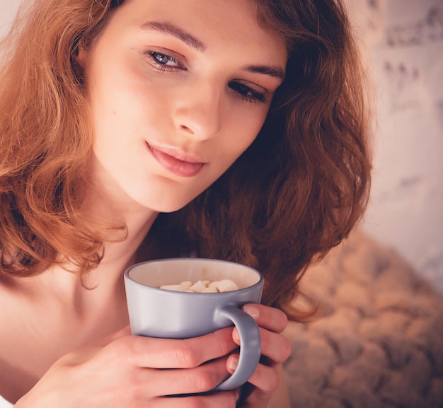 그녀의 침대 라이프 스타일 개념에서 커피를 마시는 아름 다운 금발 여자