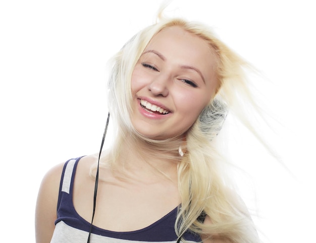 Beautiful blond woman in headphones listening to music on white background