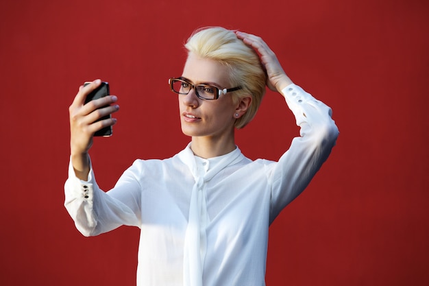 Beautiful blond woman looking at mobile phone 