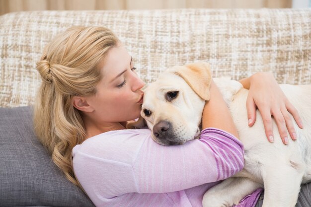 ペットの犬とソファーの上に美しいブロンド