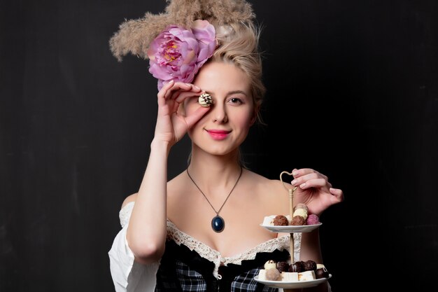 Красивая блондинка графиня с шоколадными конфетами