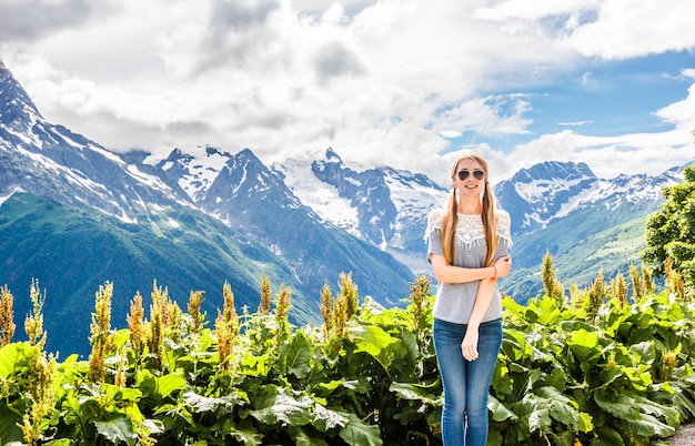 Foto bella ragazza bionda sullo sfondo del paesaggio delle montagne