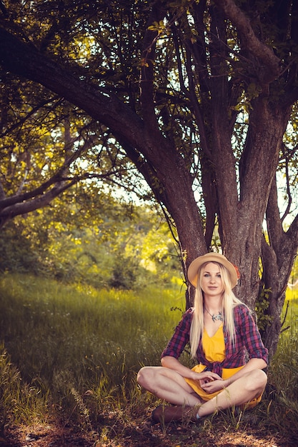 자연에서 모자, 격자 무늬 셔츠와 드레스에 아름 다운 금발 소녀